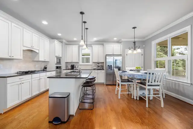 Bright kitchen with white cabinets, an island and wood floors